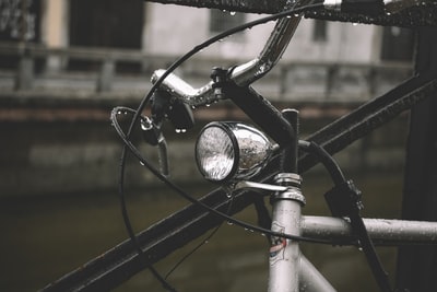 在白天灰色自行车靠在黑色的金属栅栏
